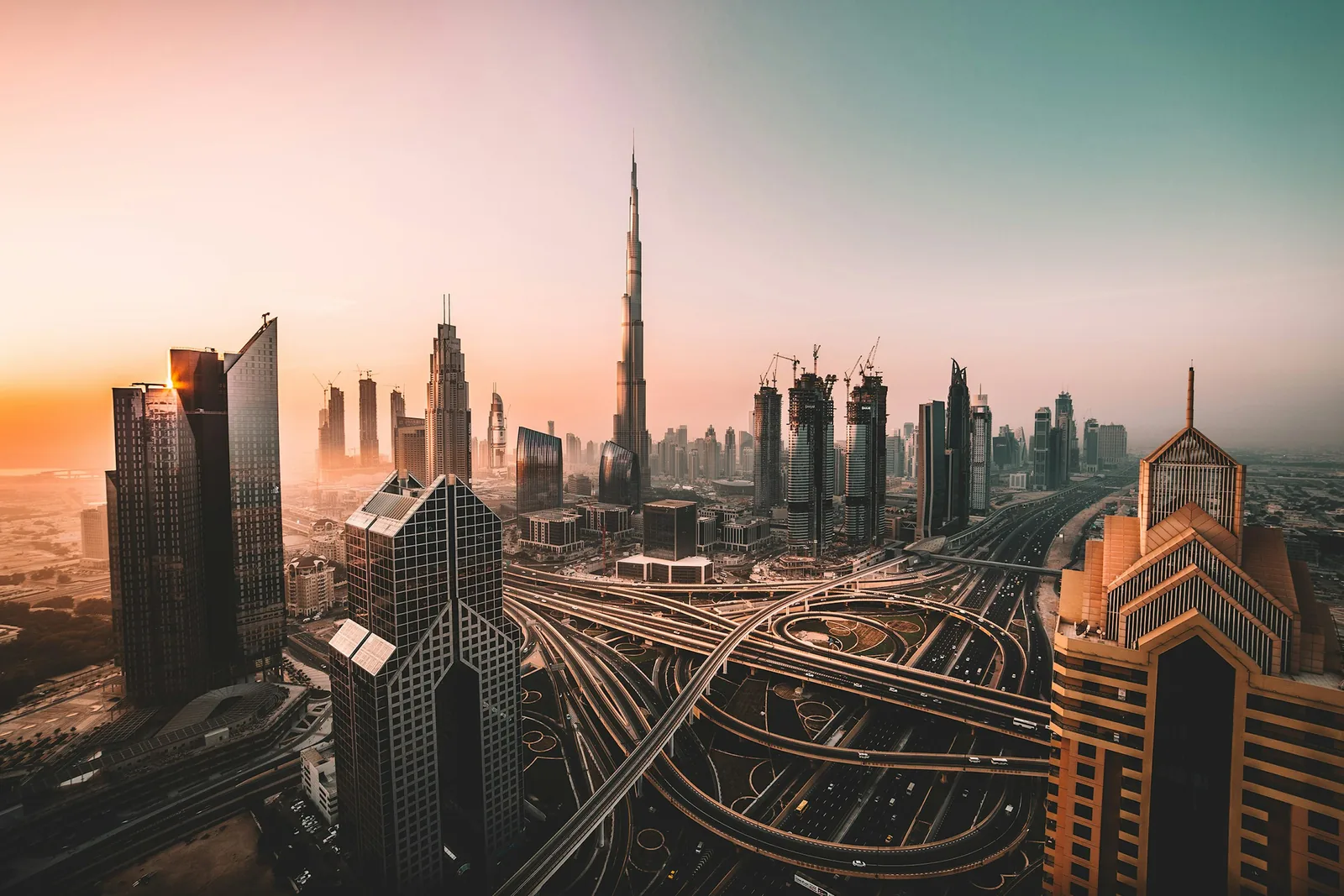Downtown Dubai au lever du soleil : Burj Khalifa et les échangeurs de la ville. Cette vue illustre le quartier, pas le tracé exact de la E11.